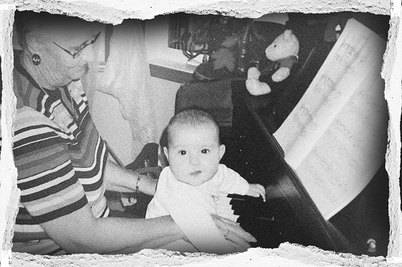 baby playing piano on a grandmas lap