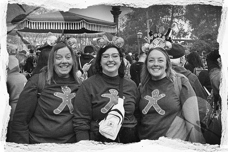 three people in matching sweaters stadning infront of a crowd