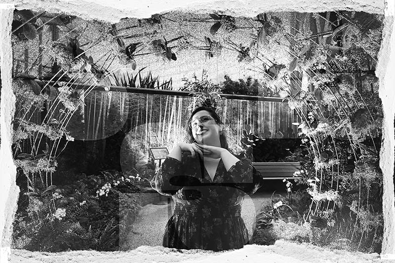 lady posing under an arch of flowers
